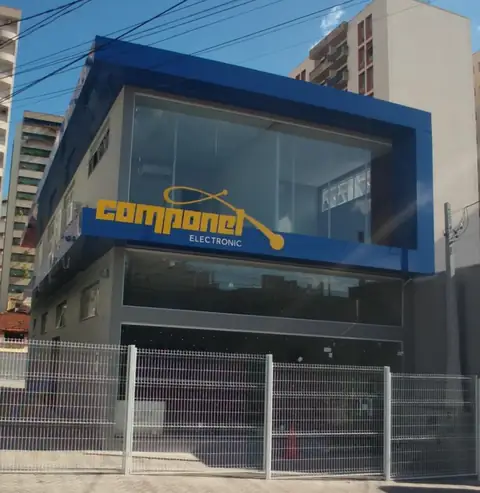 Fachada em ACM azul com letras amarelas da Componel Electronic em prédio de dois andares