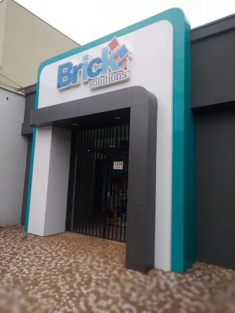 Pórtico em ACM branco, cinza e verde-água com logo da Brick Solutions na entrada