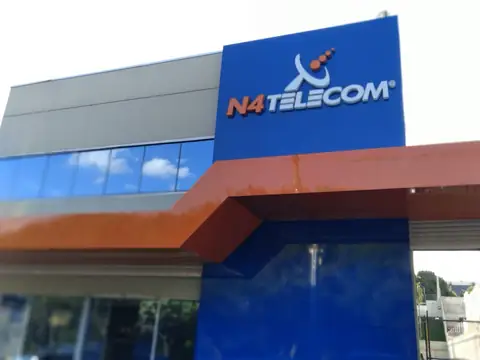 Detalhe da fachada em ACM azul e laranja com logo em relevo da N4 Telecom