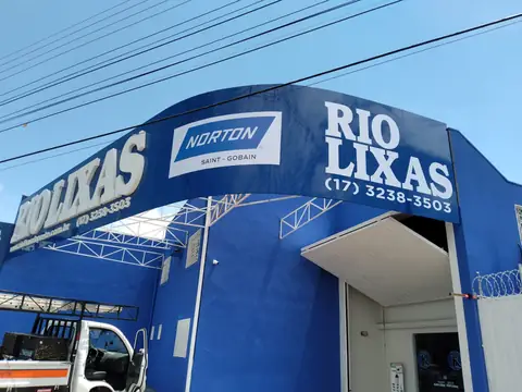Fachada azul curva com letras brancas da Rio Lixas e logo Norton, estrutura metálica aparente
