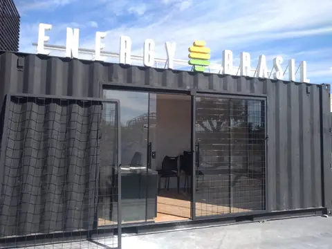 Letras caixa brancas da Energy Brasil sobre um contêiner preto adaptado como loja
