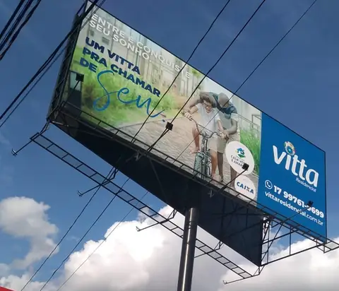 Outdoor com lona impressa da Vitta Residencial em estrutura metálica contra céu azul