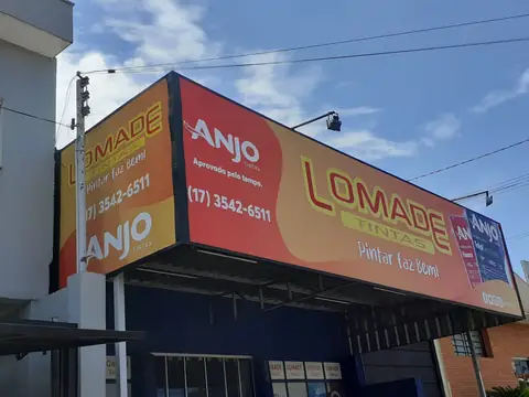Fachada em lona impressa laranja e vermelha da Lomade Tintas e Anjo Tintas, vista de baixo