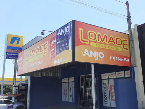 Fachada em lona impressa da Lomade Tintas e Anjo Tintas com painel lateral em ângulo