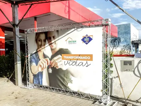 Lona impressa 'Transformando vidas' da Inter Construtora presa em estrutura de treliça