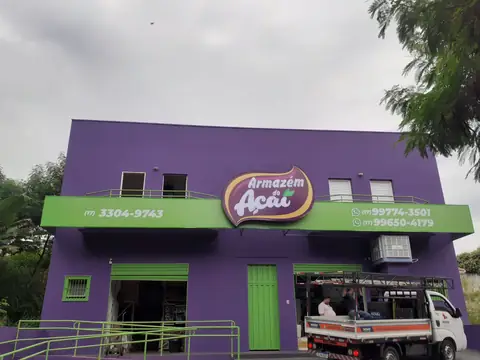 Fachada roxa e verde com logo impresso do Armazém do Açaí e caminhão ao lado