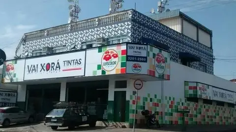 Fachada com painéis impressos da Vai Xorá Tintas e azulejos coloridos em prédio de esquina