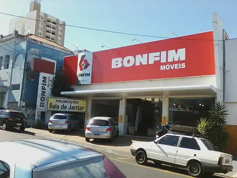 Fachada vermelha com letras brancas da Bonfim Móveis e logo, com placas laterais