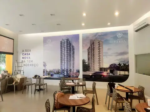 Stand de vendas com painéis impressos de dois edifícios em parede e adesivo em curva ao lado