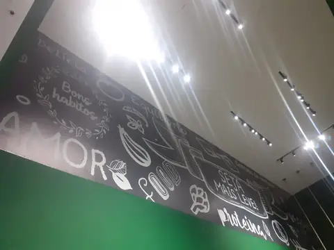 Parede interna preta com desenhos em giz de alimentos e frases como Amor e Bons hábitos