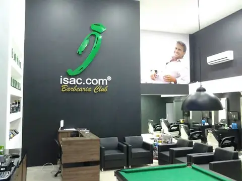 Barbearia com logotipo verde isac.com Barbearia Club sobre parede preta e mesa de sinuca