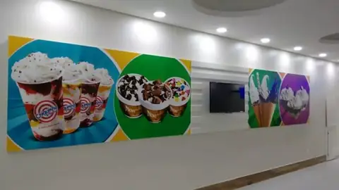 Painel impresso com copos de sorvete e sundaes em círculos coloridos na parede de uma sorveteria