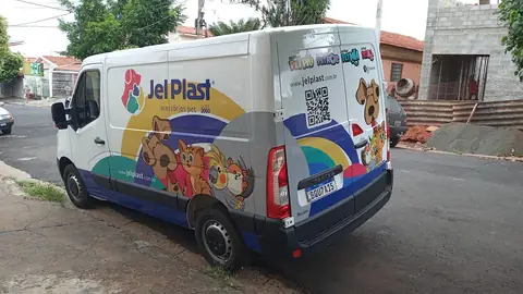 Van branca com adesivagem colorida da Jet Plast, desenhos de bichos e QR code na lateral