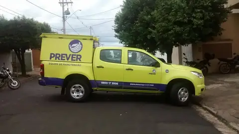 Picape verde-limão com faixa roxa e logotipo Prever na cabine, equipe de manutenção