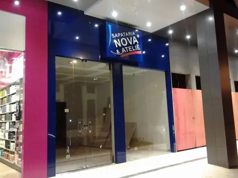 Fachada de vidro com ACM azul-marinho e rosa e painel luminoso da Sapataria Nova & Ateliê