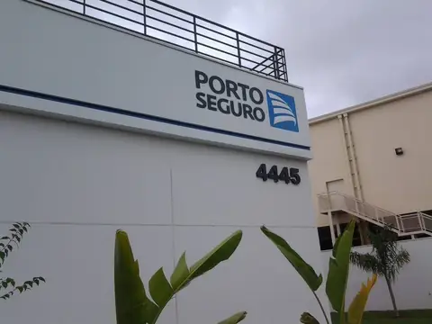 Parede branca com letras Porto Seguro e logotipo azul, número 4445 e filete azul
