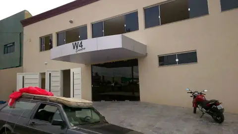 Marquise em ACM branco com letreiro W4 sobre entrada de prédio bege