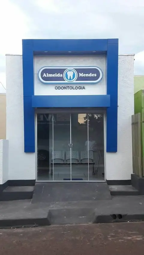 Fachada branca com moldura azul em ACM e logotipo oval Almeida Mendes Odontologia
