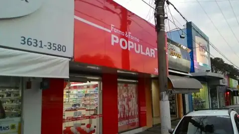 Fachada em ACM vermelho da Farma & Farma Popular com telefone 3631-3580, vista de perto