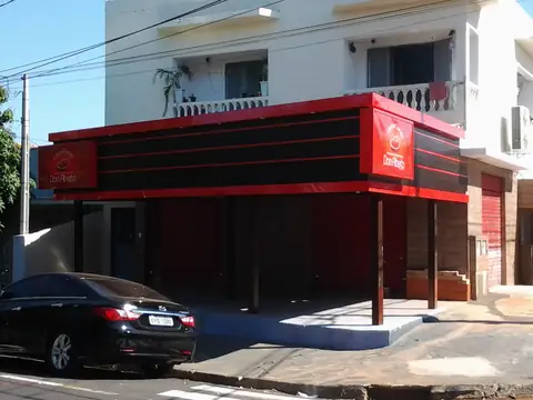 Fachada de loja com cobertura em ACM vermelho e preto com frisos e logotipo redondo vermelho