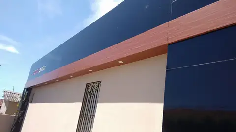 Revestimento em ACM azul-marinho com friso amadeirado na fachada de um prédio, vista de baixo