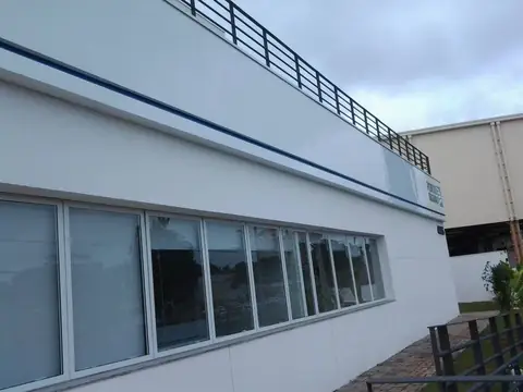 Fachada em ACM branco com faixa azul fina ao longo do prédio, vista em perspectiva