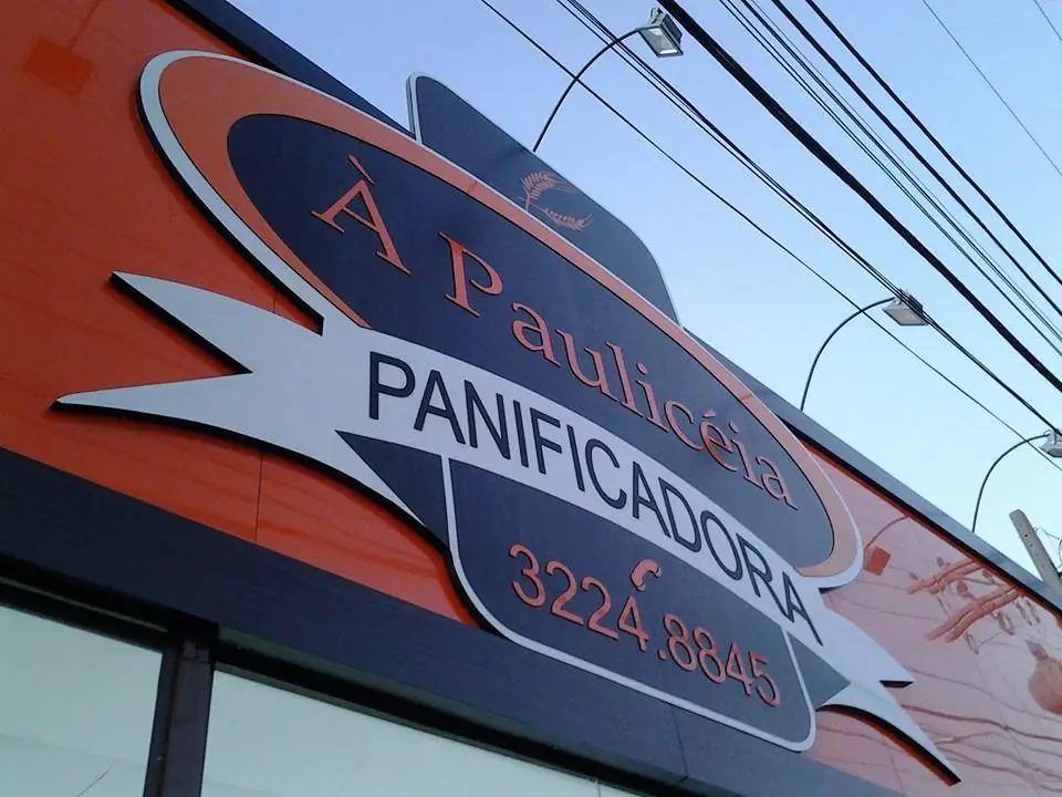Fachada em ACM laranja com painel da À Paulicéia Panificadora, vista de baixo