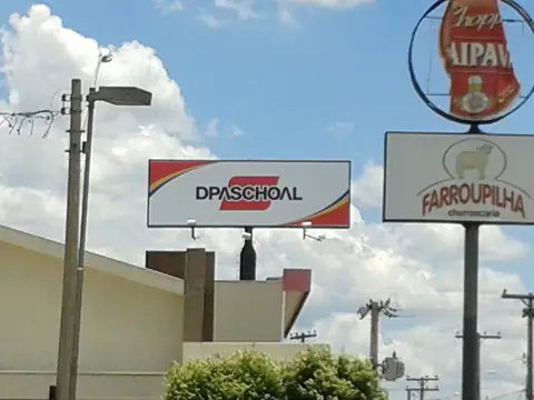 Placas em poste da DPaschoal e da Farroupilha Churrascaria, com totem de chope ao fundo