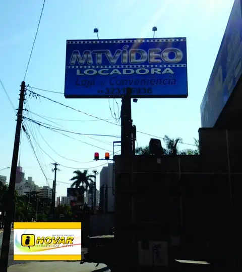 Painel luminoso azul da MTVídeo Locadora, loja e conveniência, em poste alto