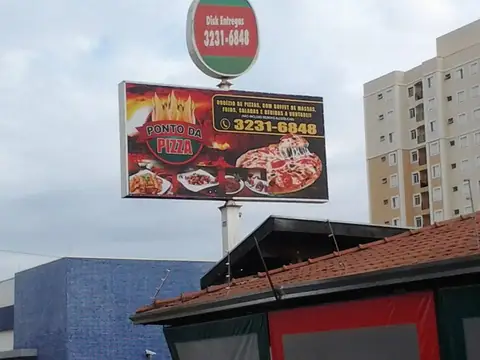 Painel luminoso da Ponto da Pizza em poste, com anel verde e vermelho no topo