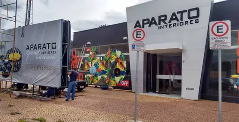 Fachada da Aparato Interiores em ACM branco com letras aplicadas, lona em instalação ao lado