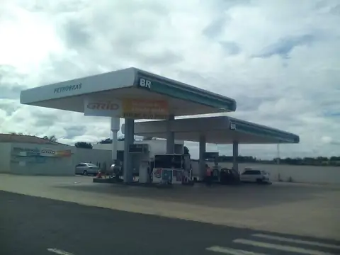 Posto Petrobras BR com cobertura branca e faixa verde sob céu carregado