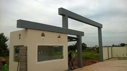 Guarita bege com pórtico em ACM cinza escuro em obra, vista em ângulo