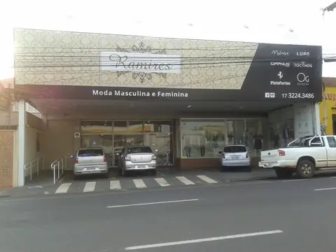 Loja de moda Ramires com revestimento em ACM claro e painel escuro com marcas, vista frontal