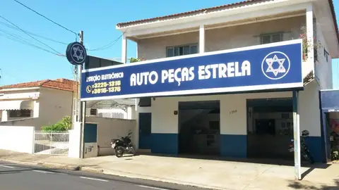 Fachada azul da Auto Peças Estrela com estrela de Davi e totem em poste