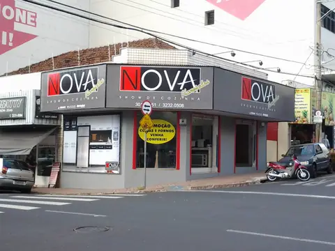 Fachada cinza e vermelha da Nova Show e Cozinha com letras do nome em destaque, de esquina