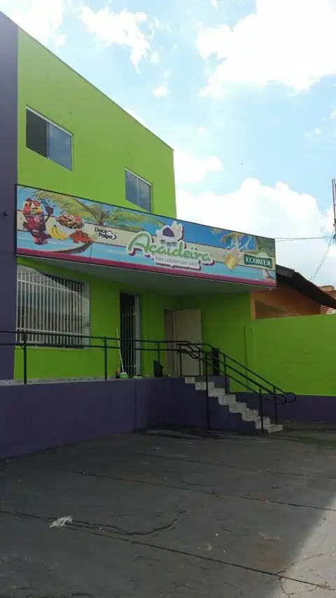 Prédio verde-limão de dois andares com faixa impressa colorida acima da entrada