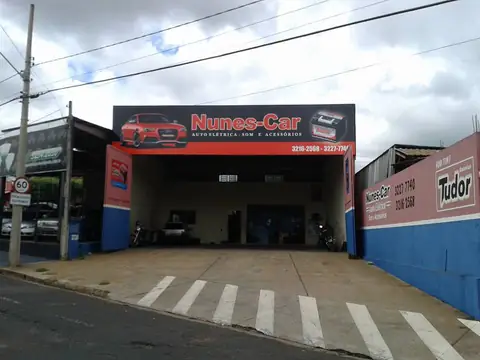 Fachada vermelha e azul da Nunes-Car com carro ilustrado no painel, vista frontal