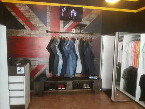 Parede de bandeira britânica em tijolo impresso atrás de arara de jeans em loja de roupas
