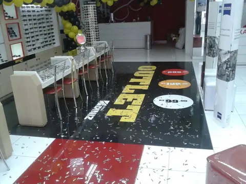 Adesivo de piso preto com texto OUTLET e preços em ótica Diniz