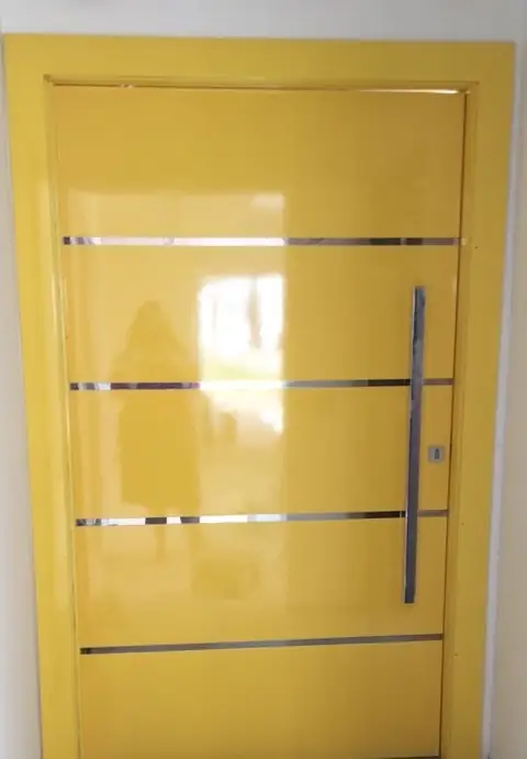 Porta pivotante amarela com frisos de inox horizontais e puxador vertical longo